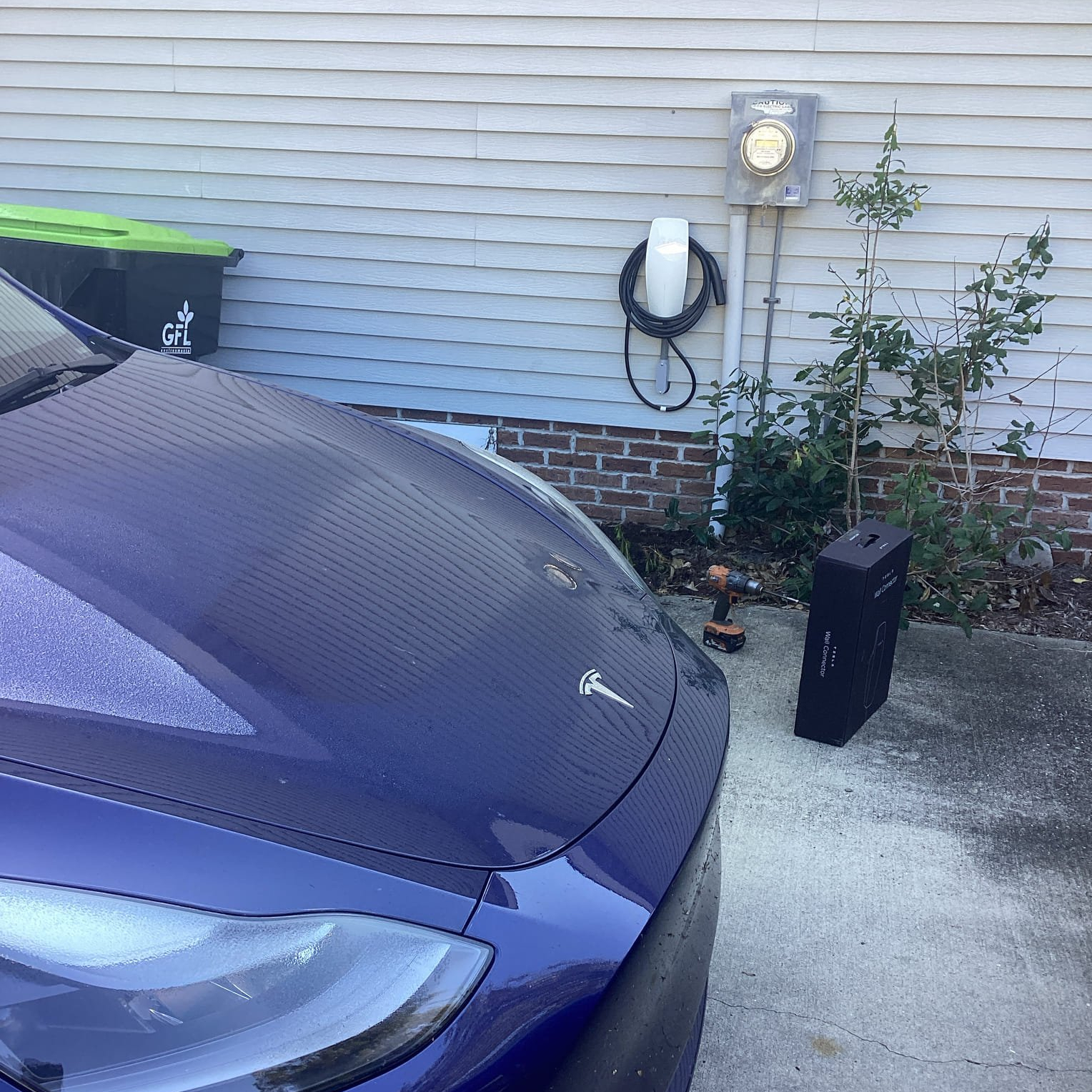 Licensed 2 Tesla car parked next to house with Tesla charger on it